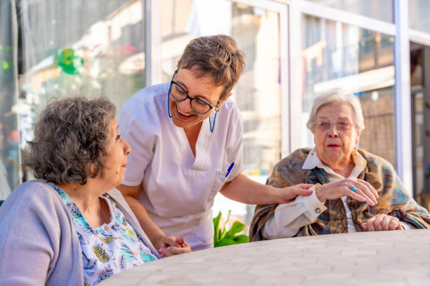 Nurse visiting a group of senior sitting in the garden of a nursing home